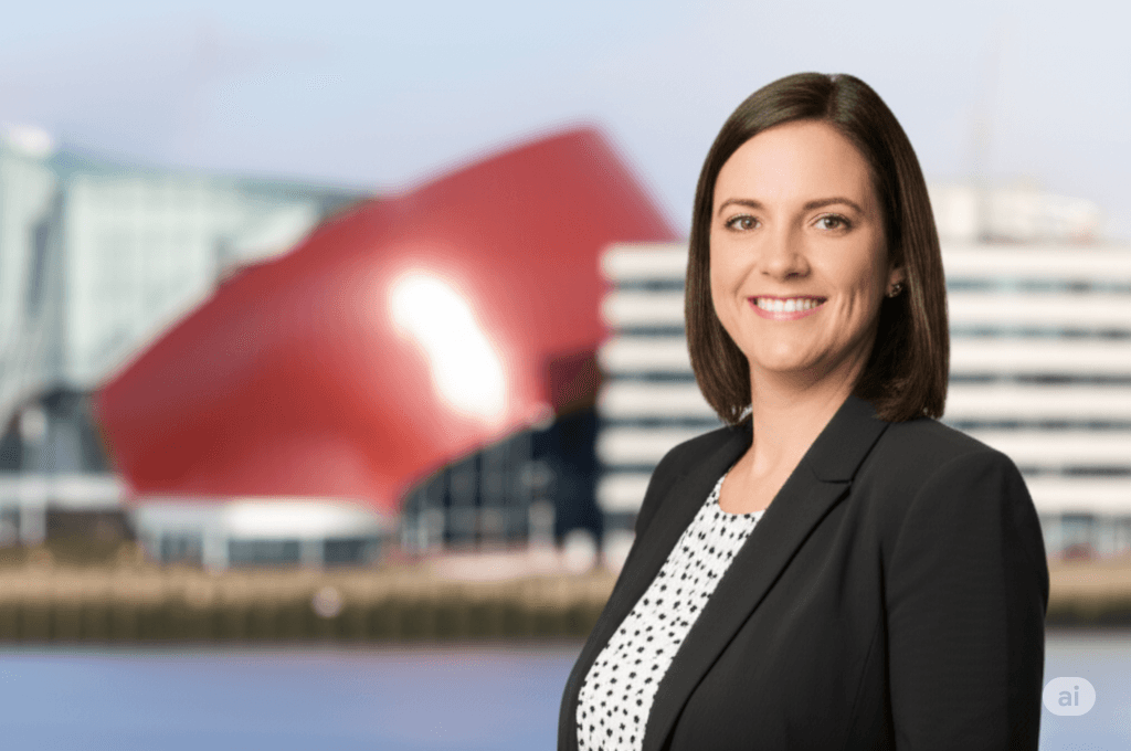 A professional AI headshot of a business woman in Cardiff, UK, with Cardiff Bay architecture blurred in the background.